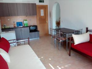 考弗尼西亚MARGARITA'S-STUDIOS的一个带桌子和红色沙发的小厨房