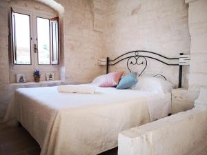 奇斯泰尼诺Trulli stett的一间卧室配有带白色床单和蓝色枕头的床。