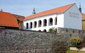 米库洛夫Městský penzion Mikulov的墙壁后面有红色屋顶的白色建筑