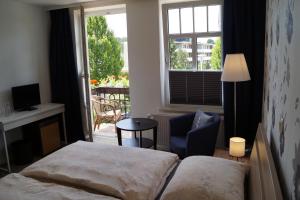 格洛米茨温蒂妮酒店的卧室配有床、椅子和窗户。