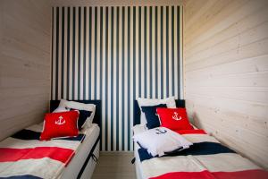 乌斯特卡Domki z klimatem的配有红色和白色枕头的客房内的两张床