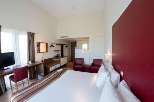 豪达高达贝斯特韦斯特城市酒店的酒店客房设有一张白色大床和红色的墙壁。