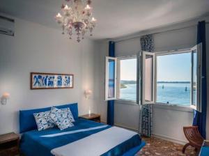 穆拉诺卡萨苏拉拉古纳旅馆的一间卧室设有蓝色的床和大窗户