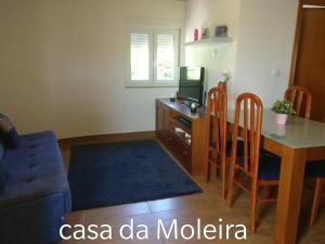阿马里什Casa da Moleira的客厅配有桌子和书桌及电视