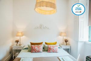 米兰德拉Dona Fina Guest House的一间卧室配有一张带枕头的床和两盏灯。