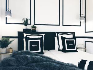 阿维拉VUT iDesign的一间卧室配有一张带黑白枕头的床