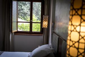 格拉纳达格拉纳达旅馆的一间卧室设有窗户和一张带枕头的床