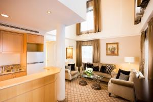 墨尔本墨尔本斯坦福广场酒店的厨房以及带沙发和桌子的客厅。