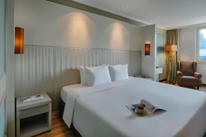胡志明市温莎广场酒店的酒店客房设有一张白色大床和椅子