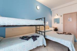 里乔内圣天使酒店的蓝色墙壁的客房内设有两张双层床。