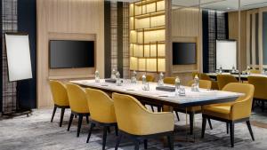 曼谷曼谷通罗驻桥套房酒店的一间会议室,配有长桌子和椅子