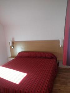 莱索尔CHALET DE BOIS MEAN的一间卧室配有红色床和红色条纹毯子