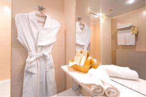 卡马河畔切尔尼鞑靼斯坦共和国商务酒店的浴室提供白色毛巾、水槽和镜子