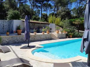 BelcodèneVILLA LA LICORNE Piscine privée, Jacuzzi, Massages, Tennis, Golf à 11km的一座房子旁带遮阳伞的游泳池