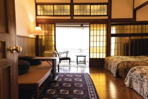 神户哈纳科亚多酒店的一间卧室配有两张床、一张桌子和一张桌子