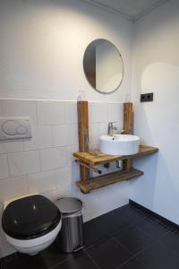 米茨兰德瓦法尔德尔旅馆的浴室设有黑色的卫生间和水槽。