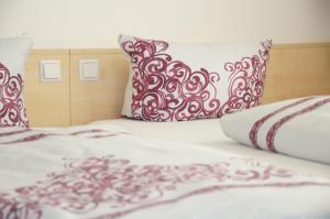 里斯河畔比伯拉赫阿德勒客房旅馆的一张带红色和白色枕头的床