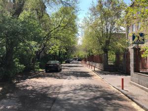 埃里温Mergelyan park by Metro Friendship的一条树木成荫的街道上停有汽车
