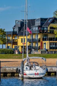 蒂门多弗施特兰德Seaside-Strandhotel的停靠在建筑物前水面上的帆船