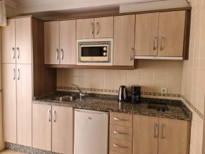 内尔哈艾尔巴里奥公寓酒店的厨房配有水槽和微波炉
