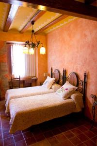 SerraA la Sombra de la Torre的一间卧室设有两张床和窗户。