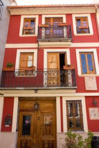 SerraA la Sombra de la Torre的红色和白色的建筑,设有阳台和门