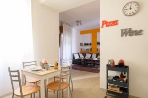 博洛尼亚Residence Griffoni的一间带桌椅和时钟的用餐室
