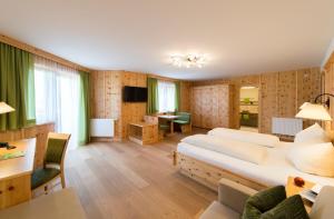 克森Hotel Waidachhof的酒店客房设有一张大床和一张书桌。