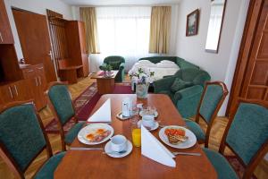布达佩斯HELIOS Hotel Apartments的用餐室配有餐桌和食物