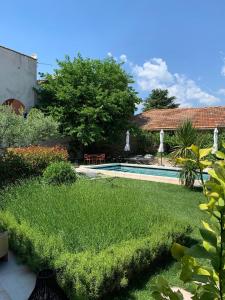 圣雷米普罗旺斯Le petit hotel的一个带游泳池和房子的花园