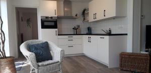 巴勒哈姆斯泰德in de Boomgaard的厨房配有白色橱柜和椅子