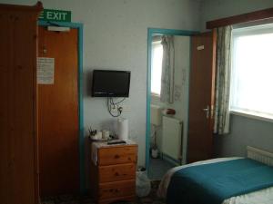 布里真德特雷曼斯旅馆的卧室配有一张床,墙上配有电视。