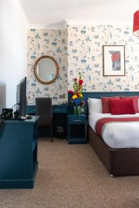 布莱顿霍夫新斯坦住宿加早餐酒店的一间卧室配有一张床、一张书桌和一面镜子