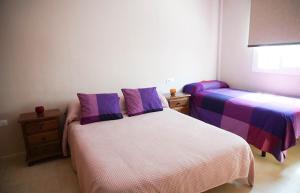 桑卢卡尔-德巴拉梅达Casa/Chalet Doñana的一间卧室配有两张紫色和白色床单