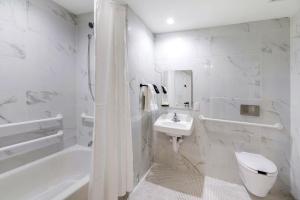 劳德代尔堡Ocean Treasure Beachside Suites的浴室配有盥洗盆、卫生间和浴缸。