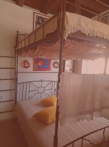 莱瓦贾Kria springs的卧室配有带白色床单的华盖双层床