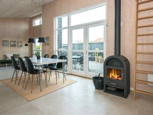 桑德比耶特6 person holiday home in Bjert的客厅设有壁炉、桌子和椅子