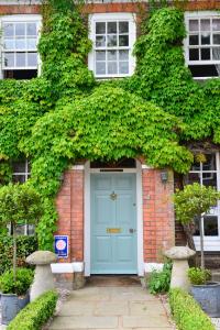 斯泰宁Springwells House的常春藤砖房的蓝色前门