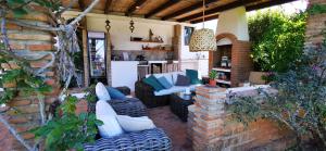 阿尔豪林德拉托里Roca Verde, Boutique Bed & Breakfast的砖墙上一个带沙发和椅子的庭院