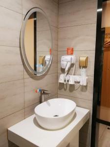 青岛7天优品青岛海洋世界海游路地铁站店的浴室设有白色水槽和镜子