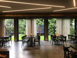 奥洛穆茨乌克拉斯库餐馆旅馆的用餐室配有桌椅和大窗户