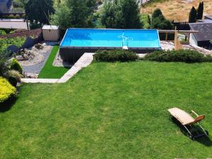 莫斯A casa dos Parladoiros的庭院里的游泳池,草地上设有长凳