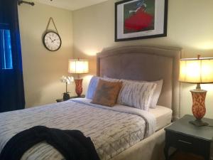 莱德森Southern Sophistication at Hickory的一间卧室配有一张带两盏灯和闹钟的床。