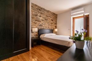 RibalongaTerraços de Baco的一间卧室设有一张床和石墙