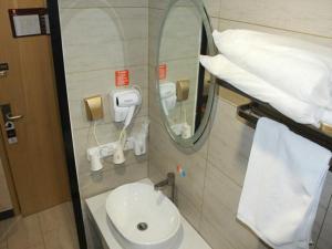 青岛7天优品青岛海洋世界海游路地铁站店的浴室设有白色水槽和镜子