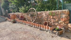 奥萨德蒙铁尔El Retiro de Cervantes的石墙,有盆栽植物和木轮