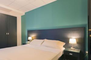 巴里Executive Business Hotel的一间卧室设有一张蓝色墙壁的大床
