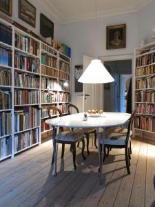 哥本哈根ApartmentInCopenhagen Apartment 931的书架前带桌椅的用餐室
