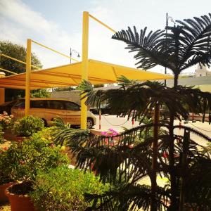 马斯喀特鲍沙尔国际酒店的种植了植物的停车场里的黄色帐篷