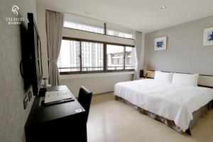 台中市Talmud Hotel Taichung的一间卧室配有一张床、一张书桌和一个窗户。